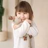 Mädchen kuschelt mit junikind Kuscheltier aus Bio-Baumwolle