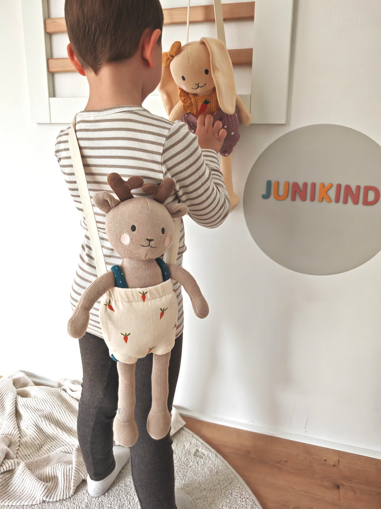Video zeigt Kind, das mit einer junikind Puppe in einer junikind Tasche die Welt entdeckt